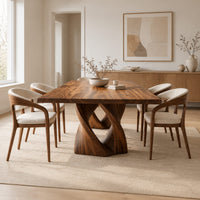 Rectangular dining table on a single pedestal of interlocking twisted ribbons in a Scandinavian dining room with white walls