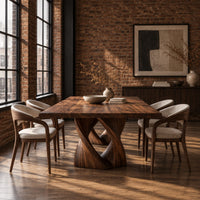 Rectangular dining table on a single pedestal of interlocking twisted ribbons in an industrial loft dining room with exposed brick