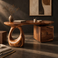 Corner detail of kidney shaped desk with a loop pedestal and a two drawer cabinet beside wood, brass and linen samples