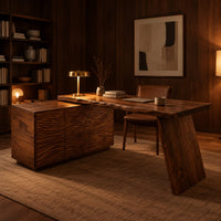 Desk with a carved cabinet end and one angled slab leg in an evening home office with walnut wall paneling