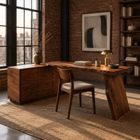 Desk with a carved cabinet end and one angled slab leg in an industrial loft home office with exposed brick