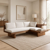 L shaped sofa with cream cushions on a low wood platform base in a Scandinavian living room with white walls