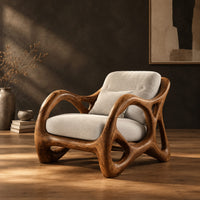 Lounge chair with large loop openings in the arms and sculpted legs in a dark studio against a charcoal plaster wall