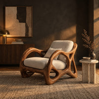 Lounge chair with large loop openings in the arms and sculpted legs in a dark living room at golden hour