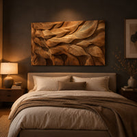 Rectangular wall art panel of layered carved leaves in deep relief above a bed in a dusk lit bedroom