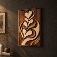 Framed wall art carved with heart shaped leaves in layered relief on a dark charcoal plaster wall