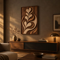 Framed wall art carved with heart shaped leaves in layered relief above a low console in an evening living room