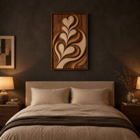 Framed wall art carved with heart shaped leaves in layered relief above a bed in a dusk lit bedroom