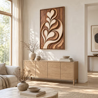 Framed wall art carved with heart shaped leaves in layered relief above a light oak sideboard in daylight