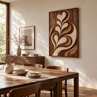 Framed wall art carved with heart shaped leaves in layered relief beside a dining table in natural light