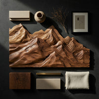 Detail of layered ridge carved mountain wall art beside wood, brass and linen samples