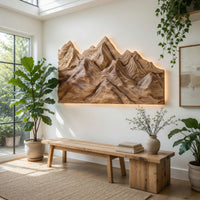 Layered ridge carved mountain wall art in a bright sunroom with green plants