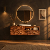 Floating vanity with layered carved ridges and an open shelf on the right in a dark bathroom at golden hour