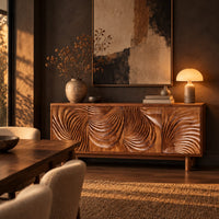 Sideboard with four layered swirl carved panels on sturdy legs in a dark dining room at golden hour