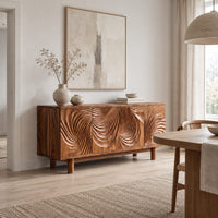 Sideboard with four layered swirl carved panels on sturdy legs in a Scandinavian dining room with white walls