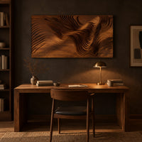 Wide wooden wall art panel with layered carved wave ridges above a desk in a dark study corner