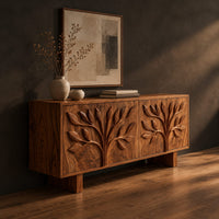 Low sideboard carved with two leafy branch trees across four doors, three-quarter view showing the grain
