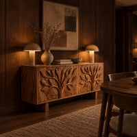 Low sideboard carved with two leafy branch trees across four doors in an evening dining room with walnut wall paneling