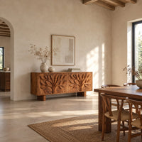 Low sideboard carved with two leafy branch trees across four doors in a bright open plan dining room