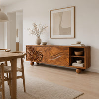 Sideboard with leaf carved doors, ball feet and an open shelf bay in a Scandinavian dining room with white walls