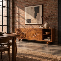 Sideboard with leaf carved doors, ball feet and an open shelf bay in an industrial loft dining room with exposed brick