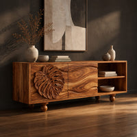 Sideboard with a carved leaf door, open shelf bay and ball feet, three-quarter view showing the grain