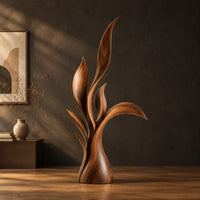 Wood sculpture of layered leaf blades rising from one tapered base in a dark studio against a charcoal plaster wall