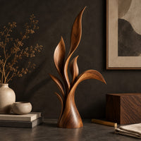 Corner detail of wood sculpture of layered leaf blades rising from one tapered base beside wood, brass and linen samples