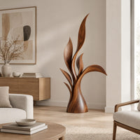 Wood sculpture of layered leaf blades rising from one tapered base in a Scandinavian living room with white walls
