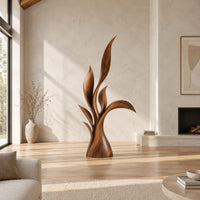 Wood sculpture of layered leaf blades rising from one tapered base in a bright open plan living room