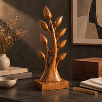 Corner detail of tree shaped wood sculpture with leaf tips and a flared trunk beside wood, brass and linen samples