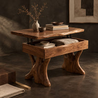 Corner detail of lift top coffee table with a natural edge top and two trunk shaped legs beside wood, brass and linen samples