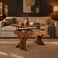 Lift top coffee table with a natural edge top and two trunk shaped legs in a dark living room at golden hour