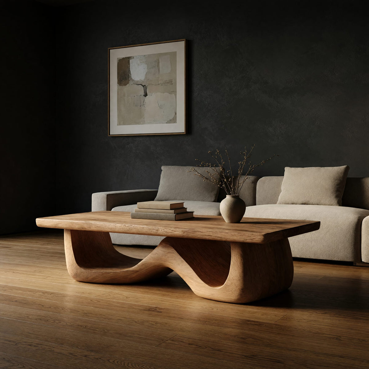 Light toned coffee table with a wave shaped base in a dark studio against a charcoal wall
