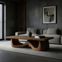 Light toned coffee table with a wave shaped base in a concrete and timber loft