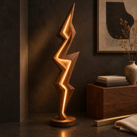 Corner detail of lightning bolt floor lamp with angular faceted sides and a glowing seam beside wood, brass and linen samples