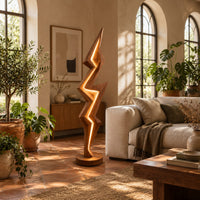 Lightning bolt floor lamp with angular faceted sides and a glowing seam in a bright living room with arched windows and plants
