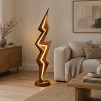 Lightning bolt floor lamp with angular faceted sides and a glowing seam in a Scandinavian living room with white walls