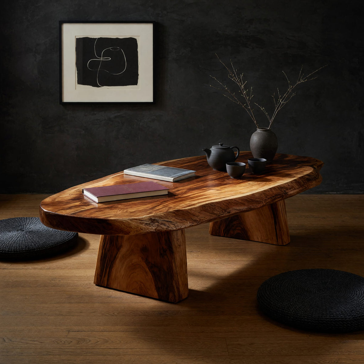 Thick live edge slab coffee table on block pedestals in a dark studio against a charcoal wall
