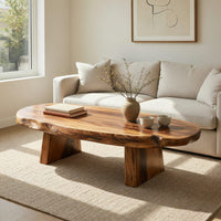 Thick live edge slab coffee table on block pedestals in an open plan space in daylight