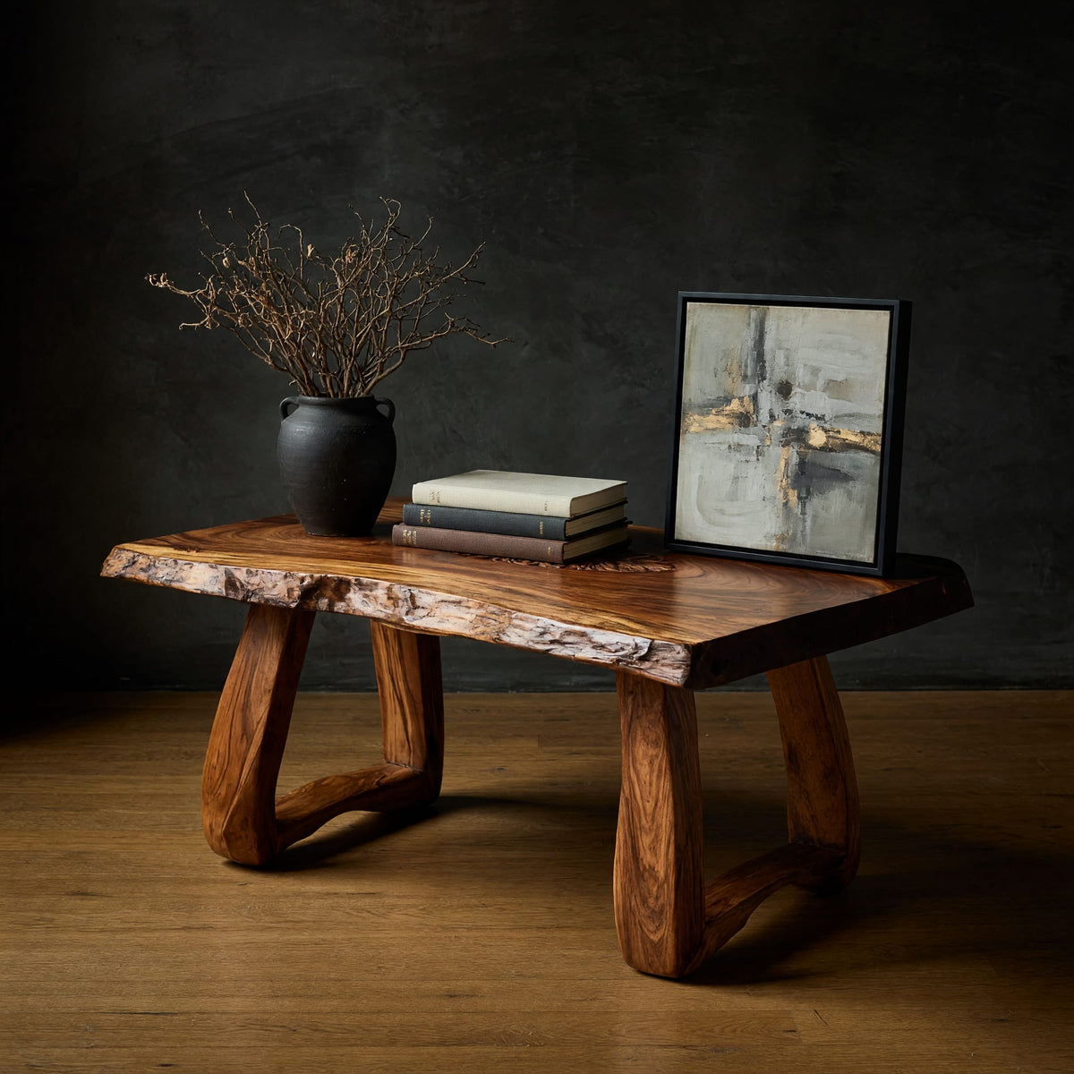 Live edge coffee table with a carved rosette inlay in a dark studio against a charcoal wall