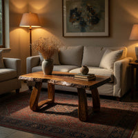 Live edge coffee table with a carved rosette inlay in an evening room lit by two lamps