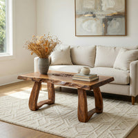 Live edge coffee table with a carved rosette inlay in a bright modern living room