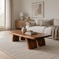 Live edge coffee table with a thick slab top and four stout tapered legs in a Scandinavian living room with white walls