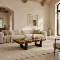 Live edge coffee table on two slab legs with arched cutouts in a bright open plan living room