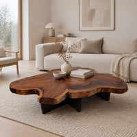 Live edge coffee table with a freeform slab top and dark angular base in a Scandinavian living room with white walls