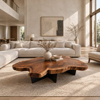 Live edge coffee table with a freeform slab top and dark angular base in a bright open plan living room