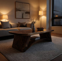 Live edge coffee table with sculpted legs and a low shelf in an evening room lit by two lamps