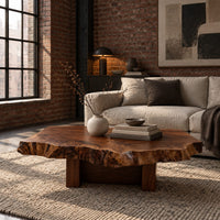Live edge coffee table with a rugged slab top and block base in an industrial loft living room with exposed brick
