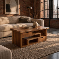 Live edge coffee table with staggered open shelves and two small drawers in an industrial loft living room with exposed brick